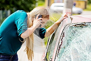 Woman dialing her phone after car crash