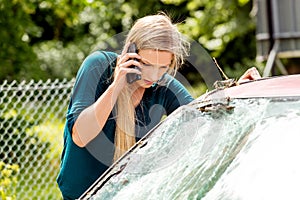 Woman dialing her phone after car crash