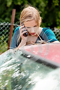 Woman dialing her phone after car crash