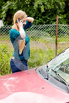 Woman dialing her phone after car crash