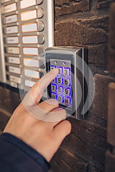Woman dialing passcode on security keypad