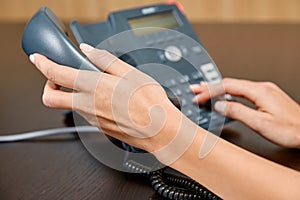 Woman dialing on a telephone