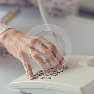 Woman dialing telephone number