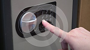 Woman dials a code on an iron safe and opens it. Close up shot