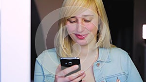 Woman with different eyes working with smartphone, Heterochromia