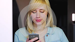 Woman with different eyes working with smartphone, Heterochromia