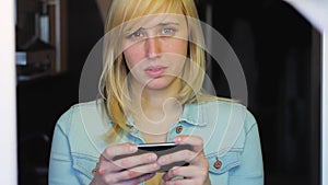 Woman with different eyes working with smartphone, Heterochromia