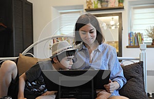 Woman digital artist and little boy portrait at home in the bedroom, mother and son