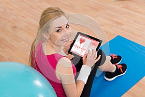 Woman With Digital Tablet Showing Heartbeat Rate