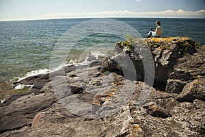 Woman with digital tablet sitting by the lake