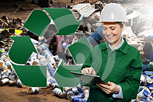 Woman with a digital tablet at a waste recycling plant.