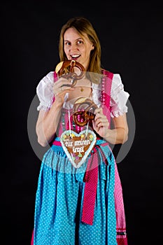 Woman in dirndl eating pretzel