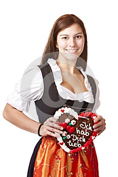 Woman in Dirndl holds gingerbread heart