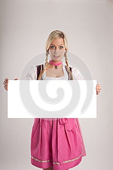 Woman with dirndl holds signboard