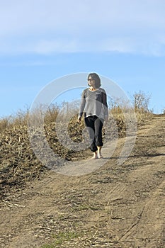 Woman on dirt path enjoying the sun