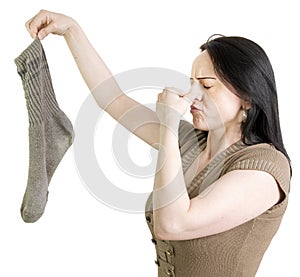 Woman with dirty sock holding her nose