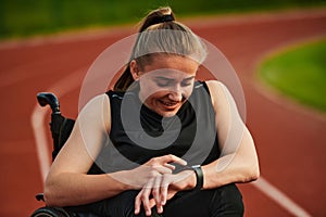 A woman with disability in a wheelchair checking a smart watch after a quick workout