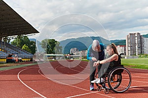 A woman with disability in a wheelchair talking with friend after training on the marathon course
