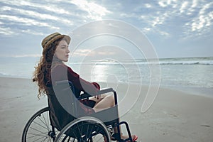 Woman disable sitting on wheelchair at beach