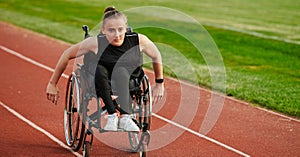 A woman with disablity driving a wheelchair on a track while preparing for the Paralympic Games