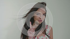 Woman disagree and shows signs not via gesture at white studio background.