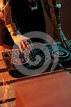 Woman disco jockey mixing sounds at dj turntables