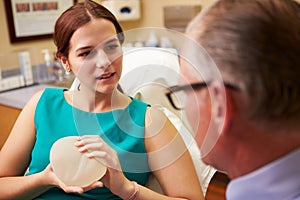 Woman Discussing Breast Augmentation With Plastic Surgeon photo