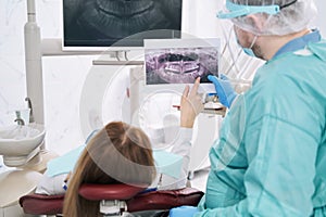 Woman discussing dental x-ray with dentist in stomatology clinic