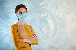 Woman with disposable mask on face against blue background. Space for text