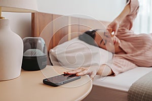 Woman in distress resting in bed, soft light illuminating the room