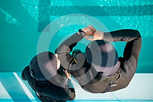 Woman and divemaster in scuba gear, diving school