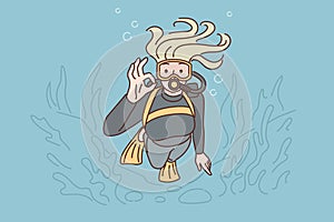 Woman diver swims underwater in scuba gear and goggles showing OK gesture exploring underwater world