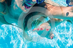 Woman diving underwater in resort swimming pool
