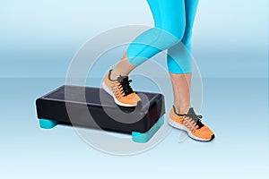 Woman do exercise on an aerobic and fitness step