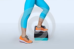 Woman do exercise on a black-turquoise fitness step