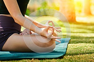 Woman do yoga practice meditating in park nature, close up cropped photo lotus position. No stress, mindfulness, inner balance