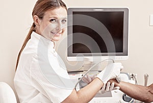 Woman doctor analyzing patient arm with tendon sonography