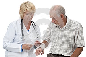 Woman doctor bandaging senior man's wrist