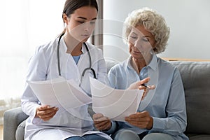 Woman doctor close health insurance with old lady patient