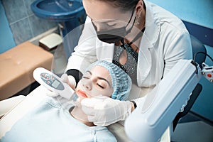 Woman doctor conducts a medical procedure to clean the face of a young girl