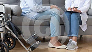 Woman doctor consulting elderly female patient at home