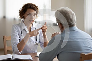 Woman doctor consulting senior patient at medical visit in hospital