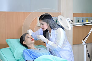 Woman doctor cosmetologist injects a filler into the cheek of the patient's woman. Cosmetology concept