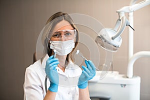 Woman doctor dentist specialist holding and showing a tooling in clinic