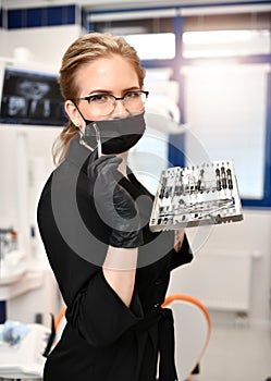 Woman doctor dentist surgeon with medical tools standing in dental
