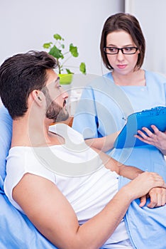 The woman doctor examining male patient in hospital