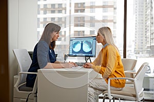 Woman doctor explaining x-ray scan to patient during medical appointment