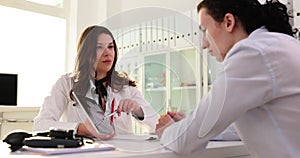 Woman doctor explains treatment to man patient on tablet