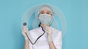 Woman doctor in face mask, hat and gloves with phonendoscope