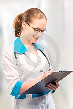 Woman doctor with a folder writes medical history photo